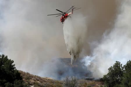 A firefighting helicopter makes a water drop at the so-called Sand Fire in the Angeles National Forest near Los Angeles, California, U.S. July 24, 2016. REUTERS/Jonathan Alcorn