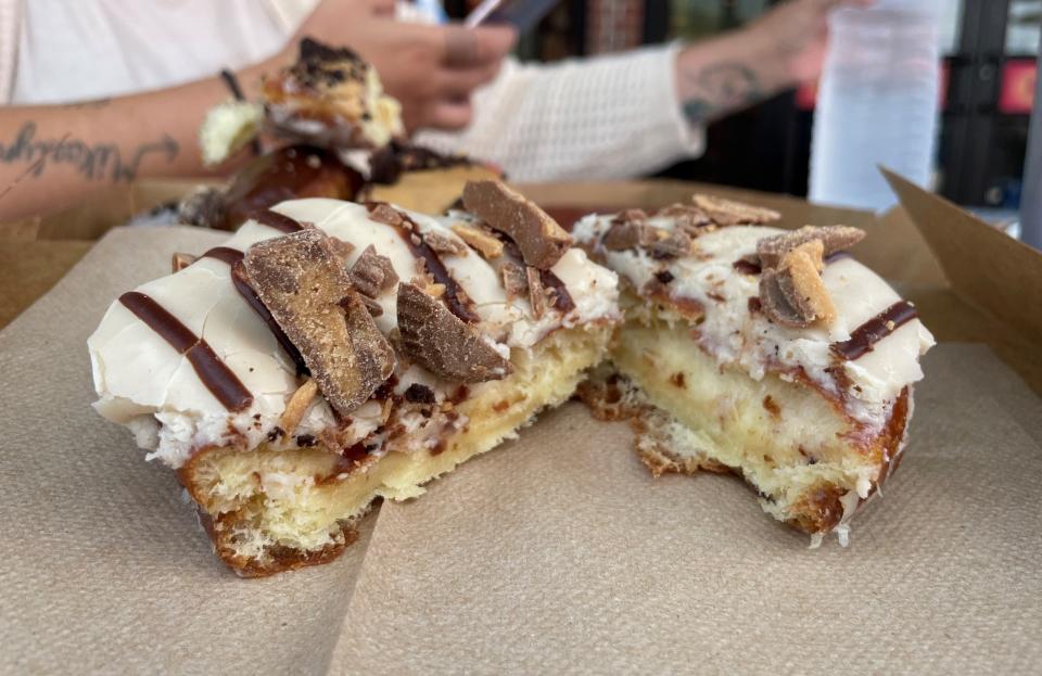 The peanut butter cup doughnut is topped with rich peanut butter icing, chocolate drizzle and sliced peanut butter cups.