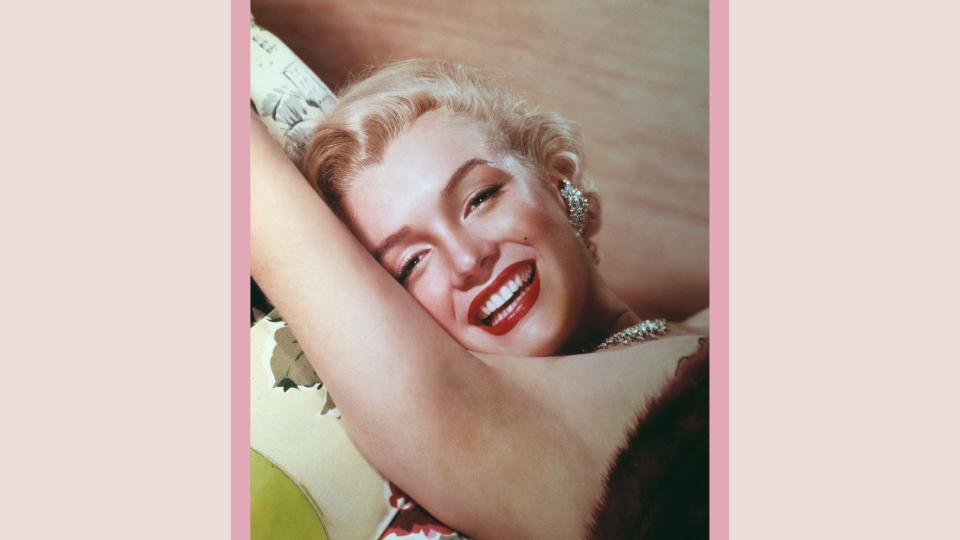 American actress Marilyn Monroe (1926 - 1962) lies smiling on a couch, circa 1955.