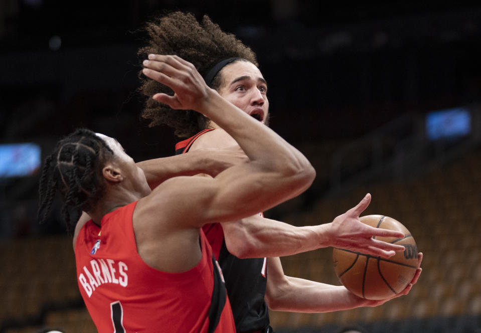 Portland Trail Blazers guard CJ Elleby (16) drives past Toronto Raptors forward Scottie Barnes (4) during first-half NBA basketball game action in Toronto, Sunday Jan. 23, 2022. (Frank Gunn/The Canadian Press via AP)