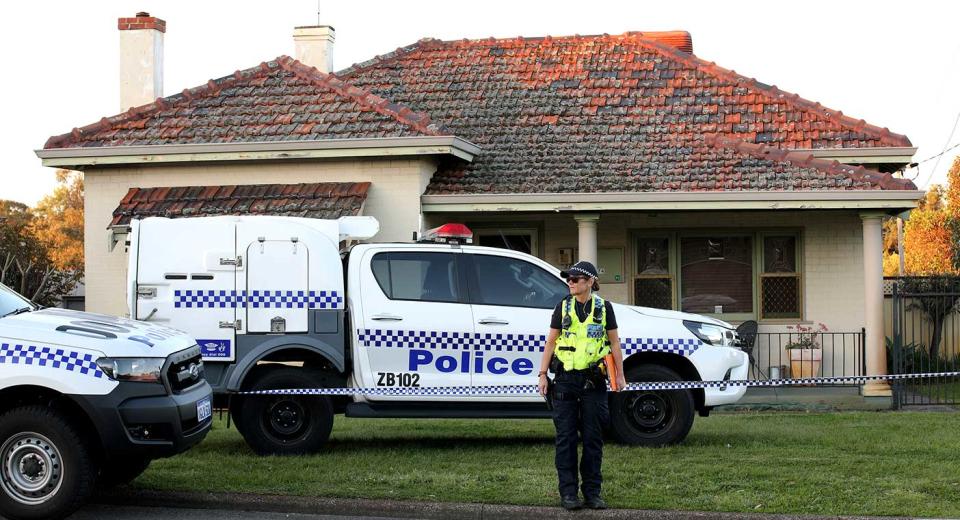 A police officer stands outside a property where five people were found dead in a suburb of Perth. (Reuters)