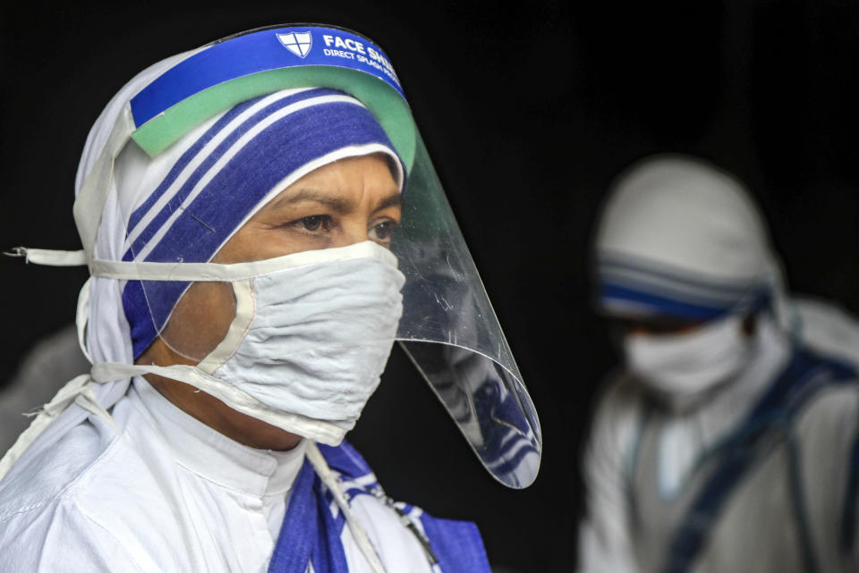 Nuns of the Missionaries of Charity, the order founded by Saint Teresa, wearing masks and face shields as precaution against the coronavirus distribute food to impoverished and homeless people to mark the anniversary of the saint's death in Kolkata, India, Saturday, Sept. 5, 2020. The Nobel Peace Prize winning Catholic nun who spent 45-years serving for the poor, sick, orphaned, and dying, died in Kolkata on this day in 1997 at age 87. (AP Photo/Bikas Das)