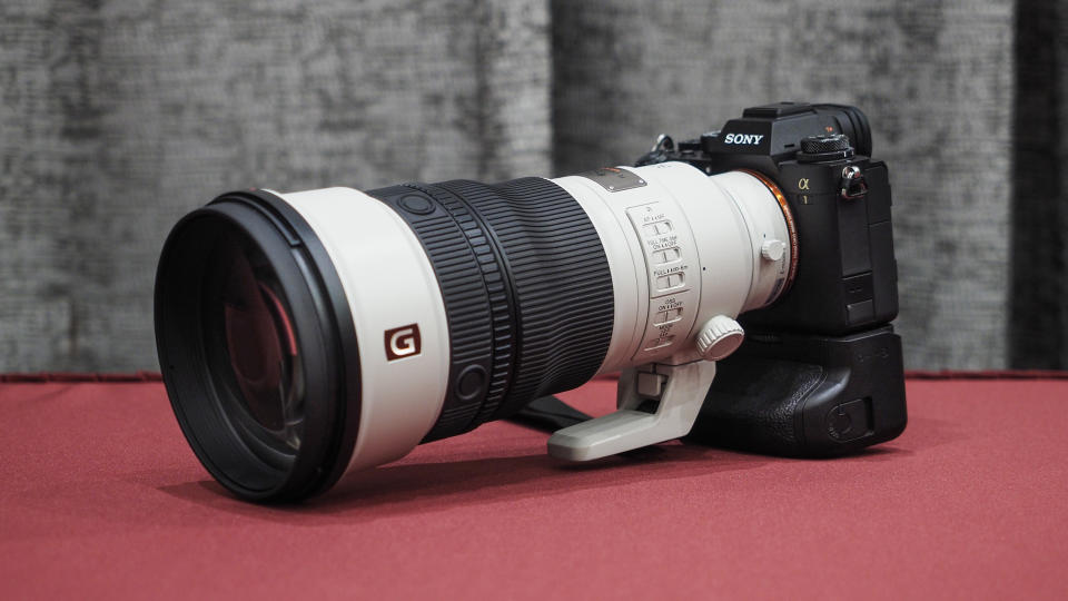 Sony FE 300mm f/2.8 GM OSS lens on a red table with grey curtains