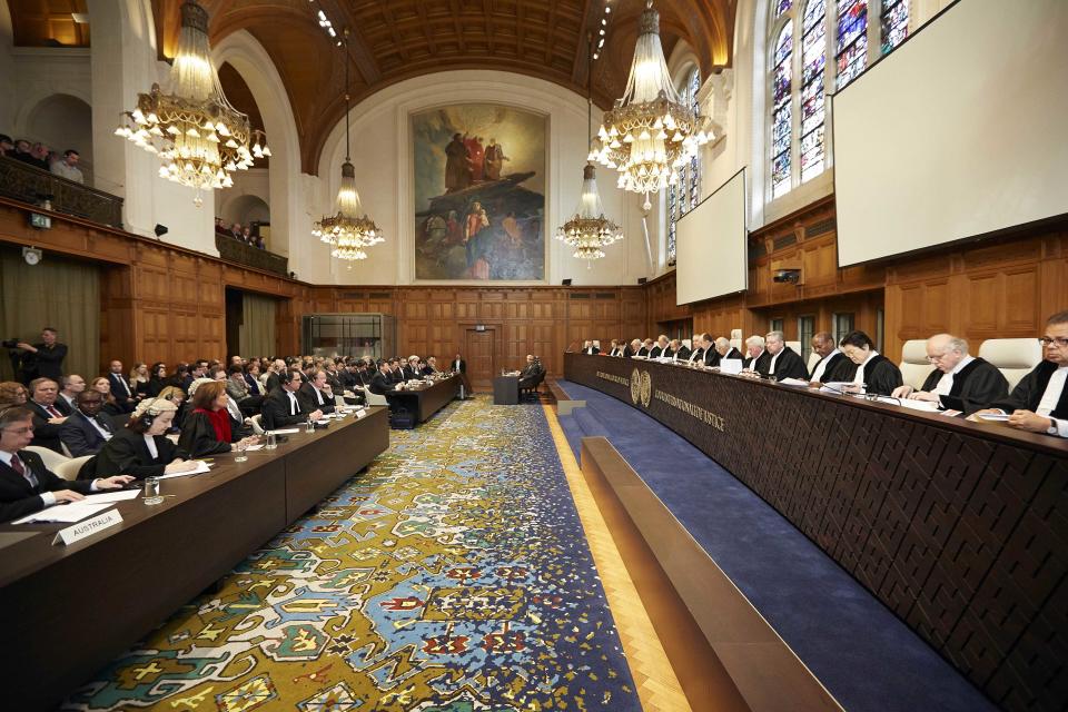 Representatives of Australia and Japan wait for the International Court of Justice to deliver its verdict in The Hague, Netherlands, Monday March 31, 2014. The International Court of Justice is ruling Monday on Australia's challenge against Japan for whaling in Antarctic waters. (AP Photo/Phil Nijhuis)