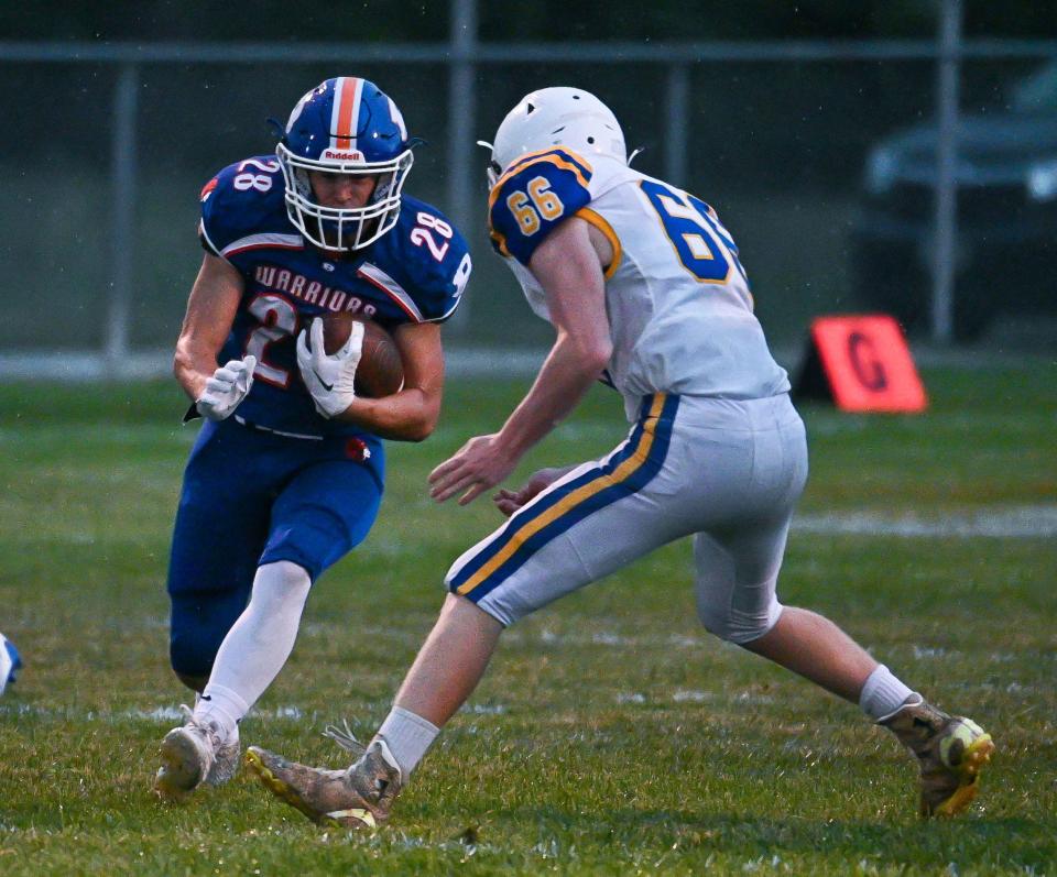 Boonsboro's Chad Wyand runs the ball as Liberty's Tyler Tucker moves in for a tackle during the Warriors' Week 2 win over the Lions.