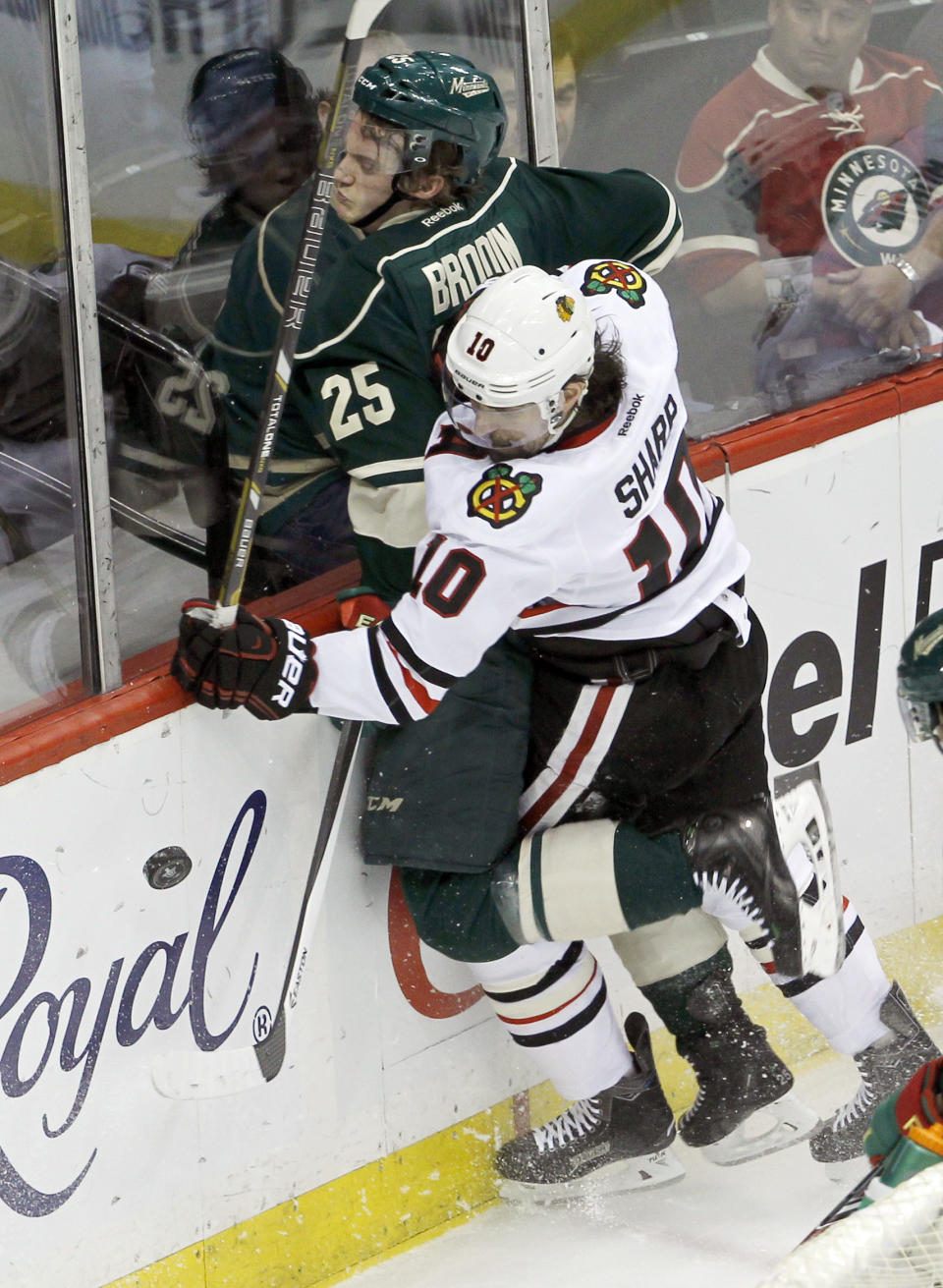 Chicago Blackhawks left wing Patrick Sharp (10) checks Minnesota Wild defenseman Jonas Brodin (25) into the boards as they battle for the puck during the first period of Game 4 of an NHL hockey second-round playoff series in St. Paul, Minn., Friday, May 9, 2014. (AP Photo/Ann Heisenfelt)