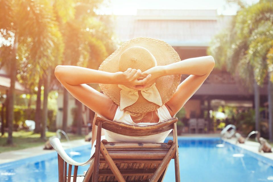 A woman relaxing at the edge of a hotel pool.