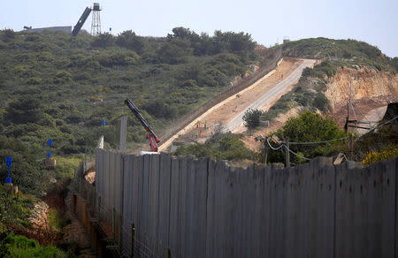 An Israeli crane builds a wall near the border, seen from Lebanon, near the village of Naqoura, March 6, 2018. REUTERS/Ali Hashisho