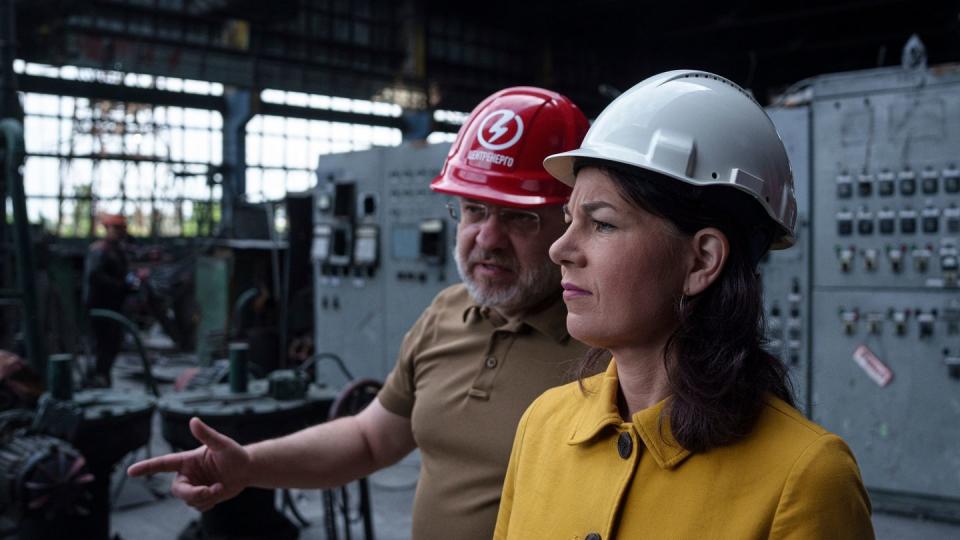 Annalena Baerbock spricht mit dem ukrainischen Energieminister German Galushchenko während eines offiziellen Besuchs in einem Wärmekraftwerk, das durch einen russischen Raketenangriff in der Ukraine zerstört wurde. (Bild: dpa)