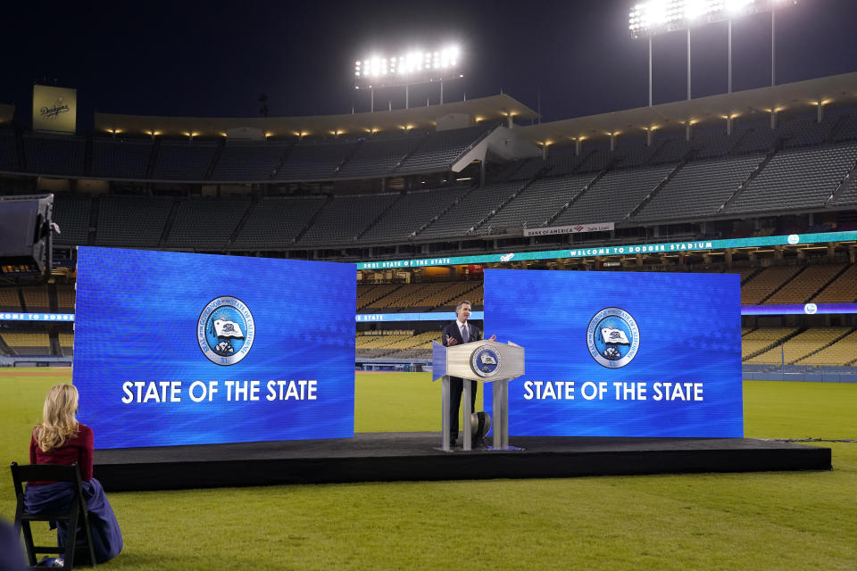 FILE In this March 9, 2021 file photo, California Gov. Gavin Newsom delivers his State of the State address from an empty Dodger Stadium as his wife Jennifer Siebel Newsom listens, in Los Angeles. Newsom suffered severe political backlash after it surfaced that he and his wife attended a party Nov. 6, 2020, with a dozen friends at the pricy French Laundry restaurant in wine country north of San Francisco. Newsom is facing the second recall of a governor in California history (AP Photo/Mark J. Terrill, File)