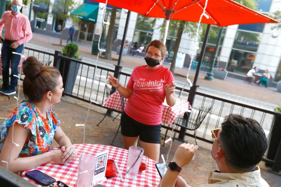 Server Paige Patterson talks to patorns at Cocozza, a pop-up ghost restaurant, with American Italian fare from the staff at Majestic Grille, served from their Main Street downtown patio cafe Friday, July 10, 2020. 
