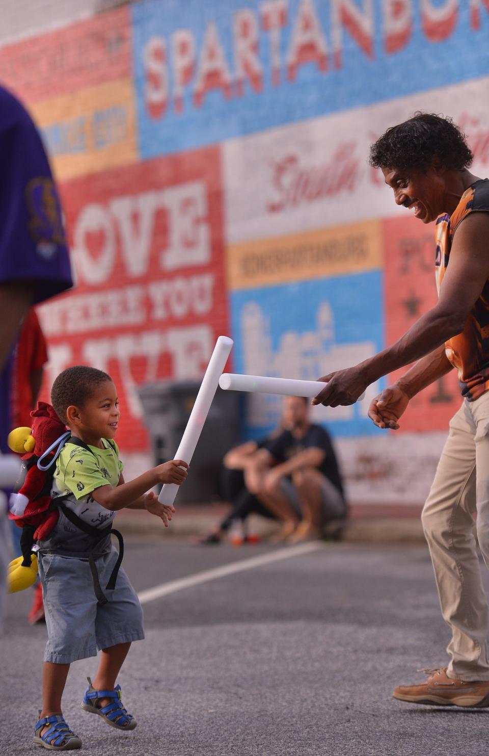 A crowd participates in the Juneteenth Block Party celebration at the Love Where You Live Park in downtown Spartanburg Friday evening, June 17, 2022. The city's weekend-long event celebrates the African-American experience since the end of slavery in 1865. Ja'Mir Williams, 3, plays with his grandfather William Brown, right, as they have fun together during the event. 