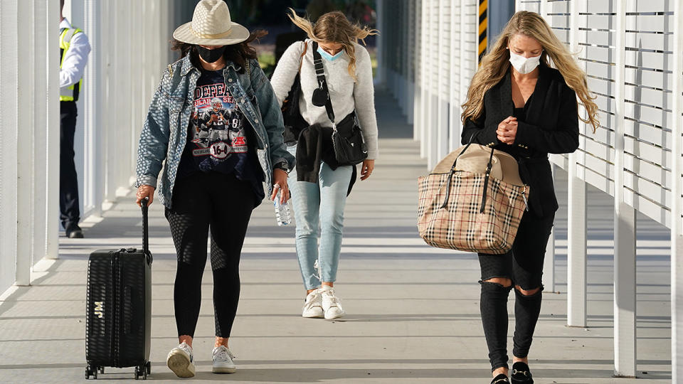 Family members, pictured here arriving in Queensland to join AFL players.