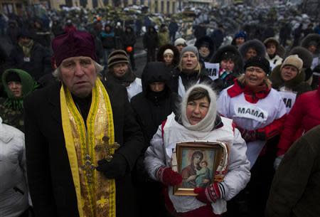 People sing religious songs at the barricades of an anti-government protesters camp near in Kiev, January 28, 2014. REUTERS/Thomas Peter