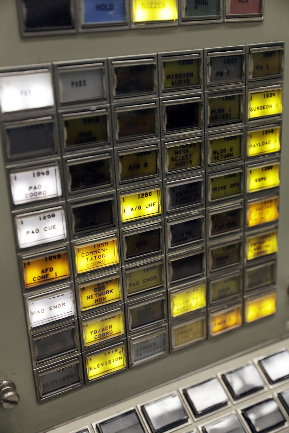 Buttons are lit on a console for the Booster Systems Engineer, the first position on the first row known as "The Trench," inside the Apollo mission control room as it is restored to replicate the Apollo mission era for the 50th anniversary of the Apollo moon landing at the NASA Johnson Space Center Monday, June 17, 2019, in Houston. (AP Photo/Michael Wyke)