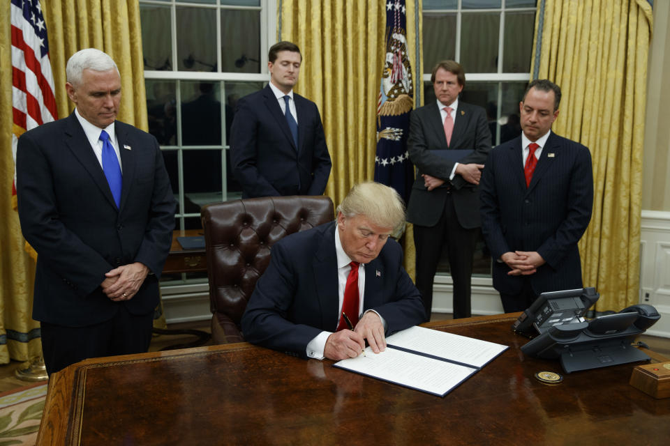 <p> FILE - In this Jan. 20, 2017, file photo,President Donald Trump, flanked by Vice President Mike Pence and Chief of Staff Reince Priebus, signs his first executive order on health care in the Oval Office of the White House in Washington. After years of objecting to President Barack Obama’s use of executive power to work around Congress, President Donald Trump and Republicans allies have all-but abandoned their public complaints about checks-and-balances and embraced the go-it-alone strategy to fast-track their dismantling President Barack Obama's policies. (AP Photo/Evan Vucci, File) </p>