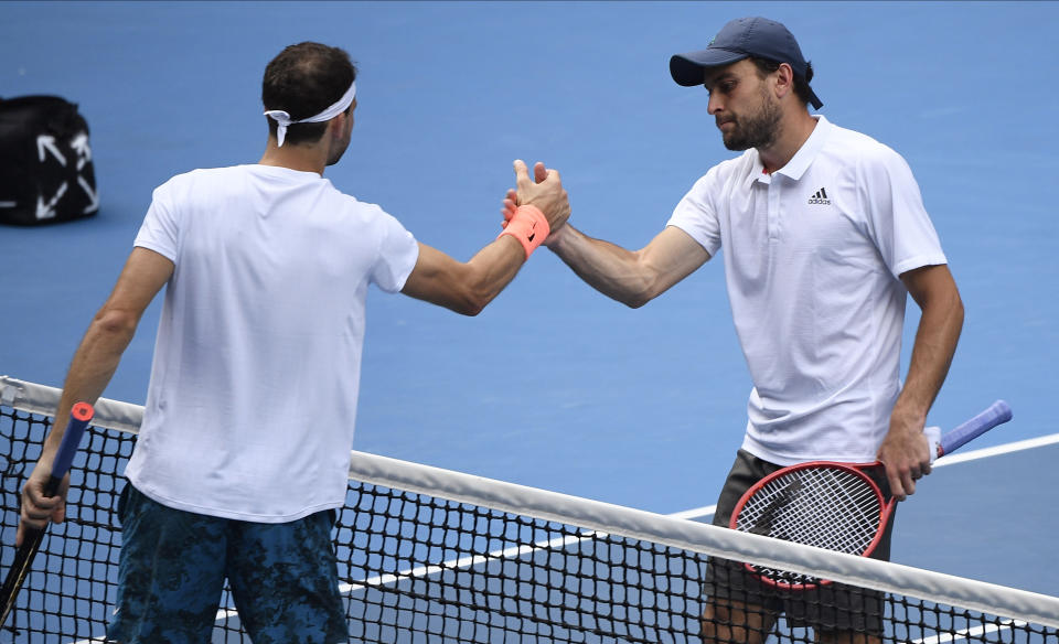 Russia's Aslan Karatsev, right, is congratulated by Bulgaria's Grigor Dimitrov after winning in their quarterfinal match at the Australian Open tennis championship in Melbourne, Australia, Tuesday, Feb. 16, 2021.(AP Photo/Andy Brownbill)