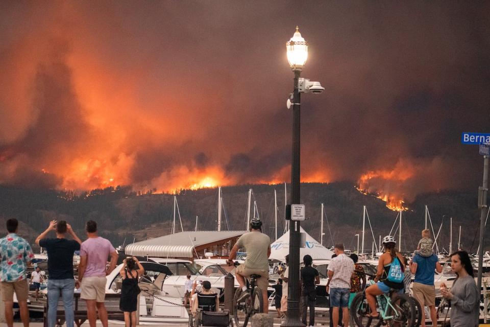 People in downtown Kelowna watch McDougall Creek wildfire burning on Aug. 17, 2023.