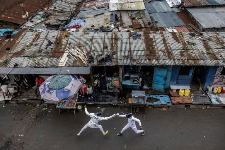 Deux membres du club d'escrime "Tsavora Fencing Mtaani" s'entraînent dans les rues de leur bidonville à Nairobi au Kenya le 9 juin 2024 (LUIS TATO)