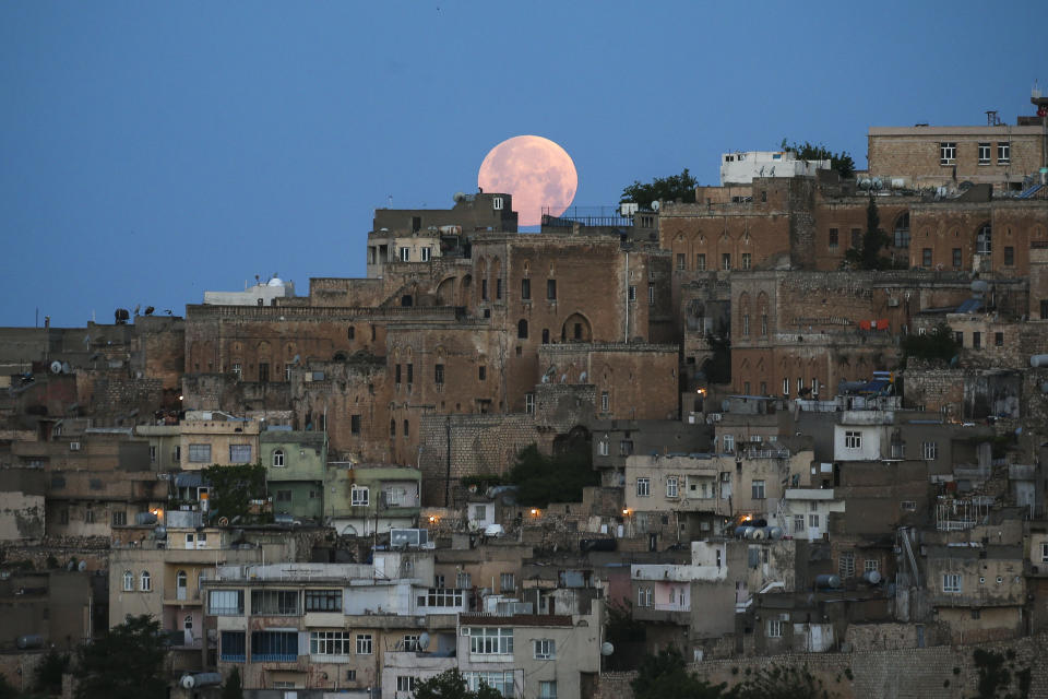 A full moon rises above the historical city center of Mardin, famous with its stone houses, in southeastern Turkey, early Monday, May 16, 2022. (AP Photo/Emrah Gurel)