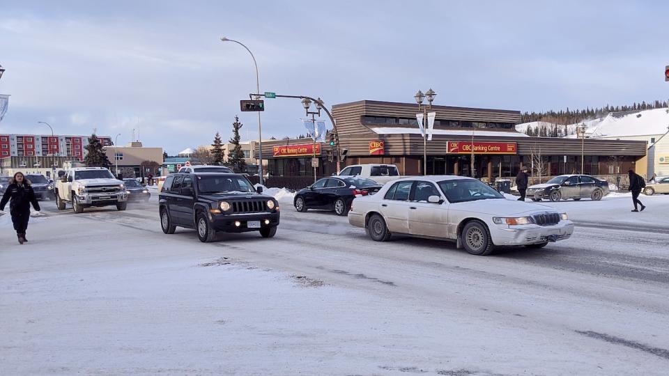 Vehicles and pedestrians travel through the intersection of Main Street and Second Avenue in downtown Whitehorse, Feb. 25, 2020.