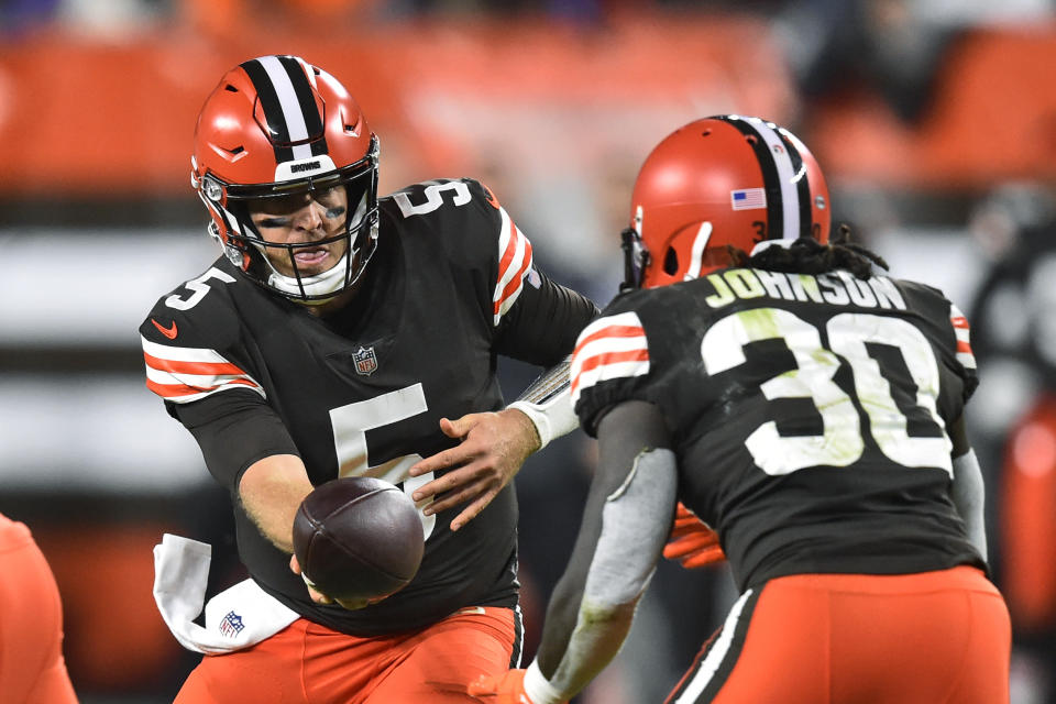 Cleveland Browns quarterback Case Keenum (5) hands the ball off to running back D'Ernest Johnson (30) during the first half of the team's NFL football game against the Denver Broncos, Thursday, Oct. 21, 2021, in Cleveland. (AP Photo/David Richard)