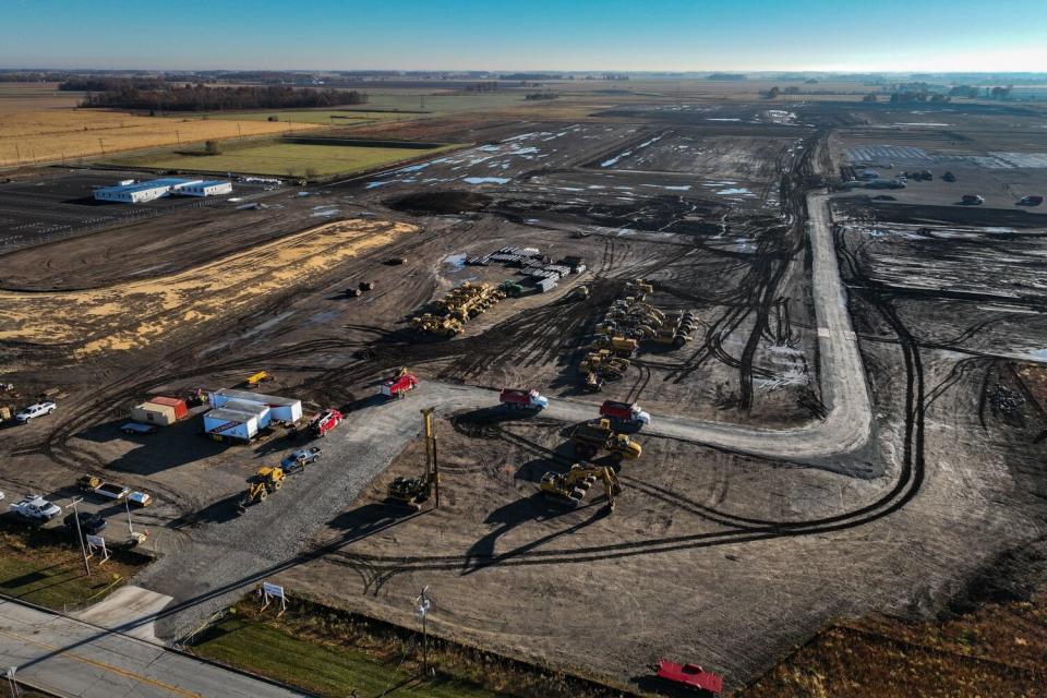 An aerial view of a sprawling construction site with trucks and other vehicles