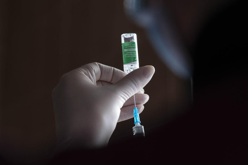 A medic prepares to administer a dose of an AstraZeneca COVID-19 vaccine marketed under the name CoviShield, to a Ukrainian serviceman at a military base in Kramatorsk, Ukraine, Tuesday, March 2, 2021. Ukraine plans to vaccinate 14.4 million people this year, or about 35% of its 41 million people. (AP Photo/Evgeniy Maloletka)