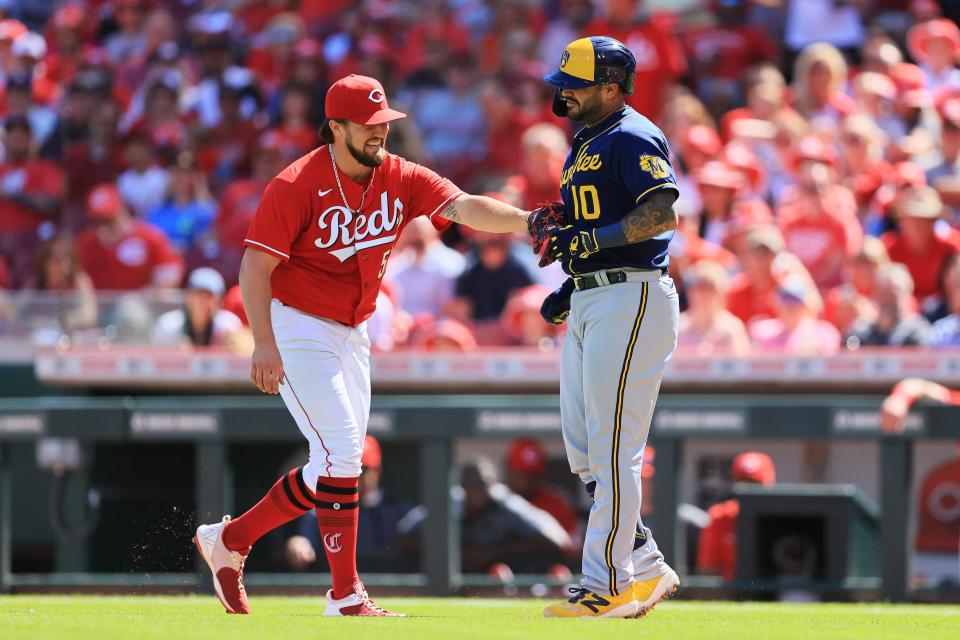 Reds pitcher Graham Ashcraft smiles as he blocks the path to first base and tags out Brewers catcher Omar Narvaez in a game on June 18.