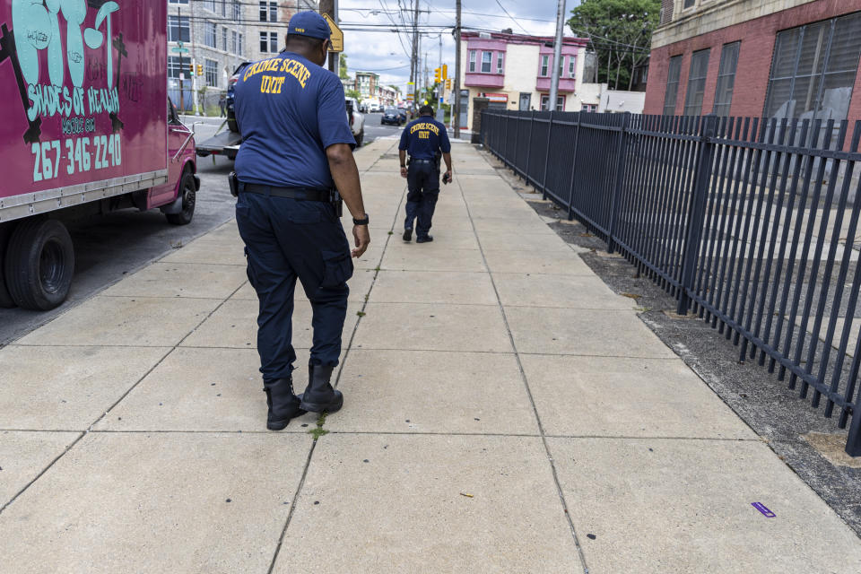 Philadelphia's Crime Scene Unit find three bullets scattered along the sidewalk in Philadelphia, on Tuesday, July 4, 2023. Police say a gunman in a bulletproof vest has opened fire on the streets of Philadelphia Monday night, killing several people and wounding two boys before he surrendered to responding officers. (Tyger Williams/The Philadelphia Inquirer via AP)