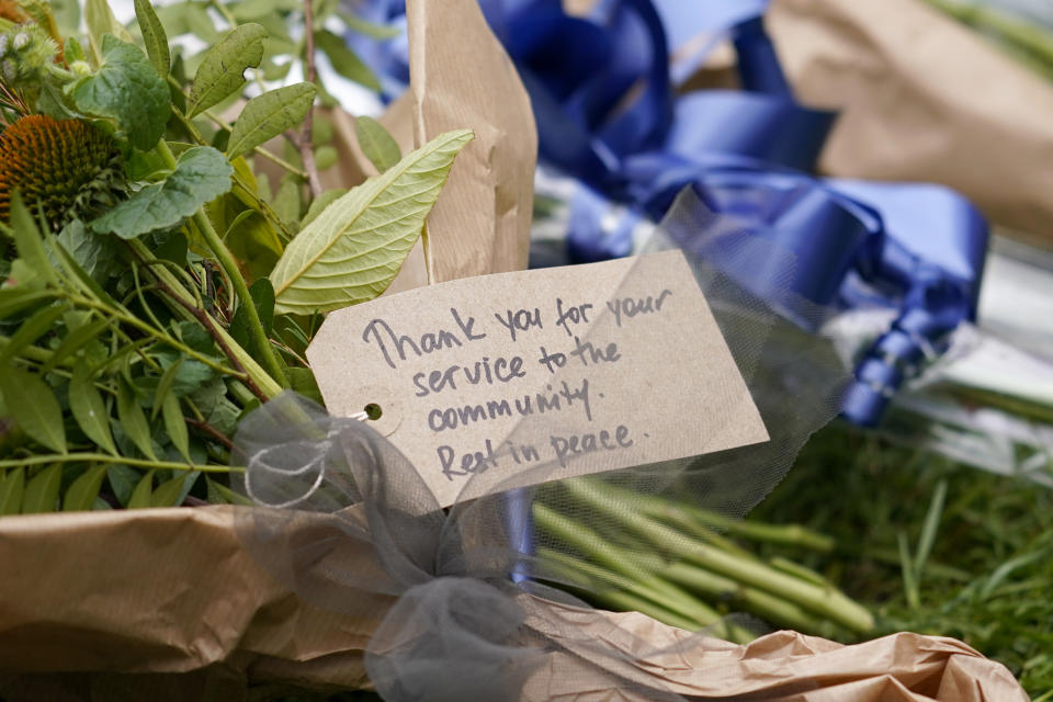 A note is seen by a floral tribute near the site where a member of Parliament was killed on Friday, in Leigh-on-Sea, Essex, England, Saturday, Oct. 16, 2021. David Amess, a long-serving member of Parliament was stabbed to death during a meeting with constituents at a church in Leigh-on-Sea on Friday, in what police said was a terrorist incident. A 25-year-old British man is in custody. (AP Photo/Alberto Pezzali)