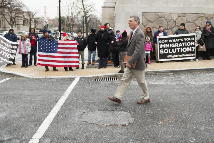 Rep. Erik Paulsen (R-Minn.) walks by immigration protesters on his way to one of the buses outside the Rayburn House Office Building as House Republicans prepare to head to Hershey, Pa., for their retreat with Senate Republicans on Jan. 14, 2015.