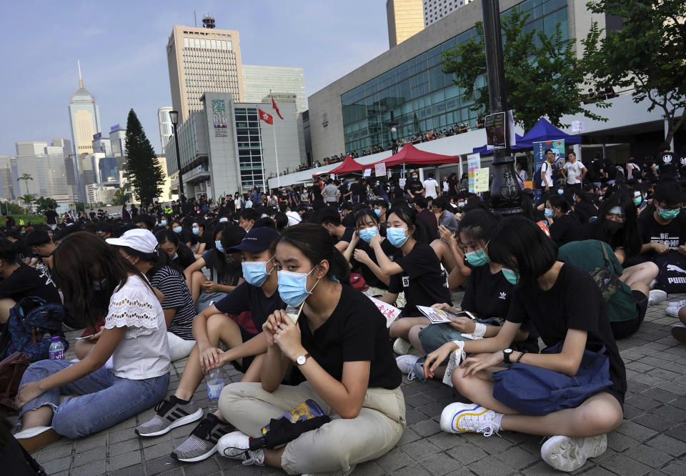 Students and others gather during a demonstration at Edinburgh Place in Hong Kong, Thursday, Aug. 22, 2019. High school students thronged a square in downtown Hong Kong Thursday to debate political reforms as residents gird for further anti-government protests. (AP Photo/Vincent Yu)