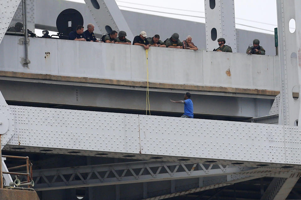 Sylvester Holt, bottom right, pleads with officers as while standing on the ledge of the Crescent City Connection Friday, Jan. 20, 2017, in New Orleans. Holt was wanted in the connection with the shooting of his wife and a Westwego police officer. (AP Photo/Jonathan Bachman)