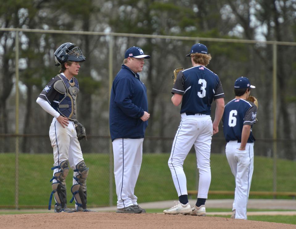Monomoy coach Steve Porter, second from left, comes to the mound to talk with pitcher Chace Robbins after the Lions scored in first inning action.