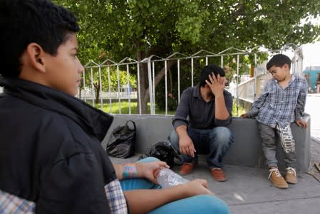 A Honduran migrant and his two sons rest after return to Mexico from the U.S. under the Migrant Protection Protocol (MPP) to wait for their court hearing for asylum seekers, in Ciudad Juarez