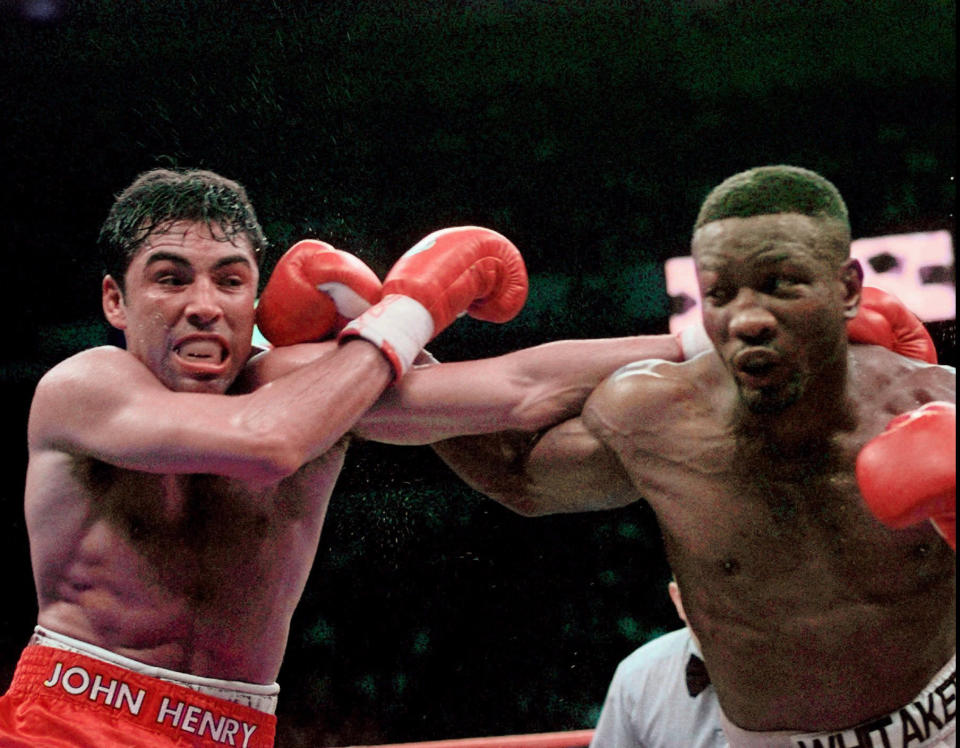 FILE - In this April 12, 1997, file photo, Oscar De La Hoya and Pernell Whitaker, right, exchange punches during their WBC Welterweight Championship fight at Thomas & Mack Center in Las Vegas. Former boxing champion Pernell Whitaker has died after he was hit by a car in Virginia. He was 55. Police in Virginia Beach on Monday say Whitaker was a pedestrian when struck by the car Sunday night, July 14, 2019. The driver remained on the scene, where Whitaker was pronounced dead. (AP Photo/Bob Galbraith, File)