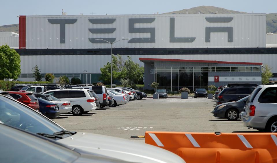 Vehicles are seen parked at the Tesla plant Monday, May 11, 2020, in Fremont, Calif. The parking lot was nearly full at Tesla's California electric car factory Monday, an indication that the company could be resuming production in defiance of an order from county health authorities.