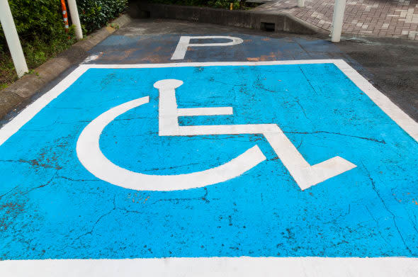 Disabled parking permit sign painted on car parking