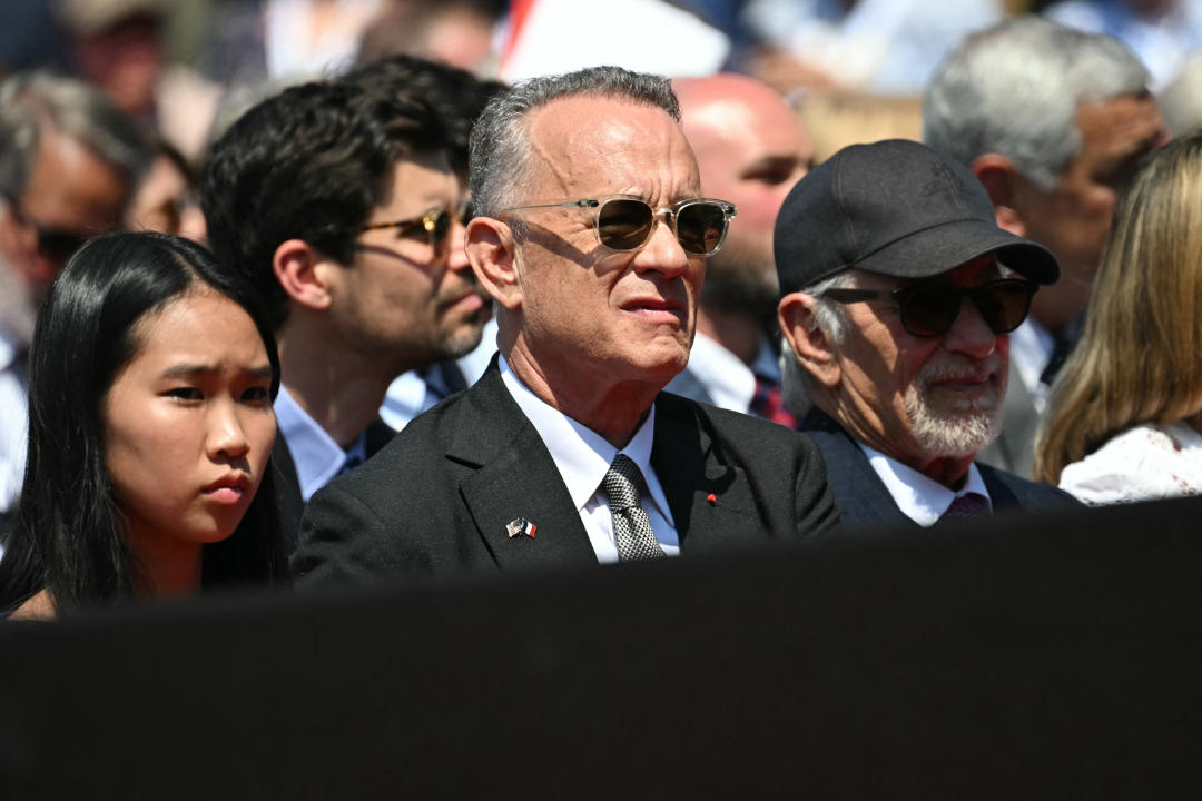 Tom Hanks and Steven Spielberg watch the proceedings in Normandy on Thursday afternoon. (Getty)