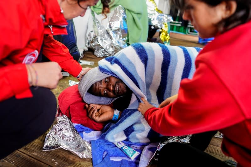 A medical crew speaks with a migrant on board a NGO Proactiva Open Arms rescue boat in the central Mediterranean Sea