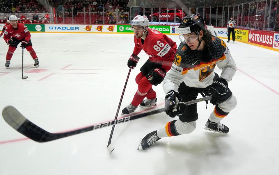 Germany's Moritz Seider, right, is challenged by Switzerland's Janis Moser during the group A Hockey World Championship match between Germany and Switzerland in Helsinki, Finland, Tuesday May 24, 2022.
