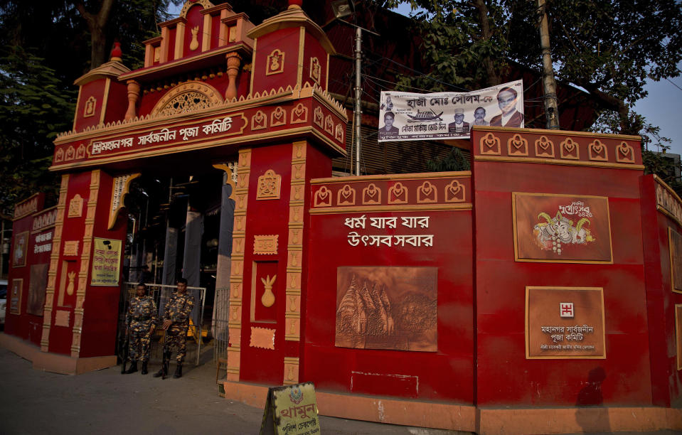 In this Tuesday, Jan. 1, 2019 photo, Bangladeshi policemen stand guard at the Dhakeshwari Temple in Dhaka, Bangladesh. While Sheikh Hasina is set to begin her third consecutive term as Bangladesh's prime minister following a landslide election victory, critics say having such an overwhelming majority in parliament could create space for her to become even more authoritarian. Still, Hasina enjoys a lot of support, especially from religious minorities in the Muslim-majority nation who say she has safeguarded their rights. At the Dhakeshwari Temple in Dhaka, Hindus poured in on Tuesday to pray and get a glimpse of the Goddess Durga, something they say was not possible under previous governments. (AP Photo/Anupam Nath)