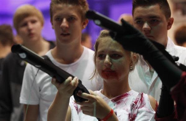 A visitor dressed like a zombie, plays "Dangerous Animals" during the Gamescom 2012 fair in Cologne August 16, 2012.
