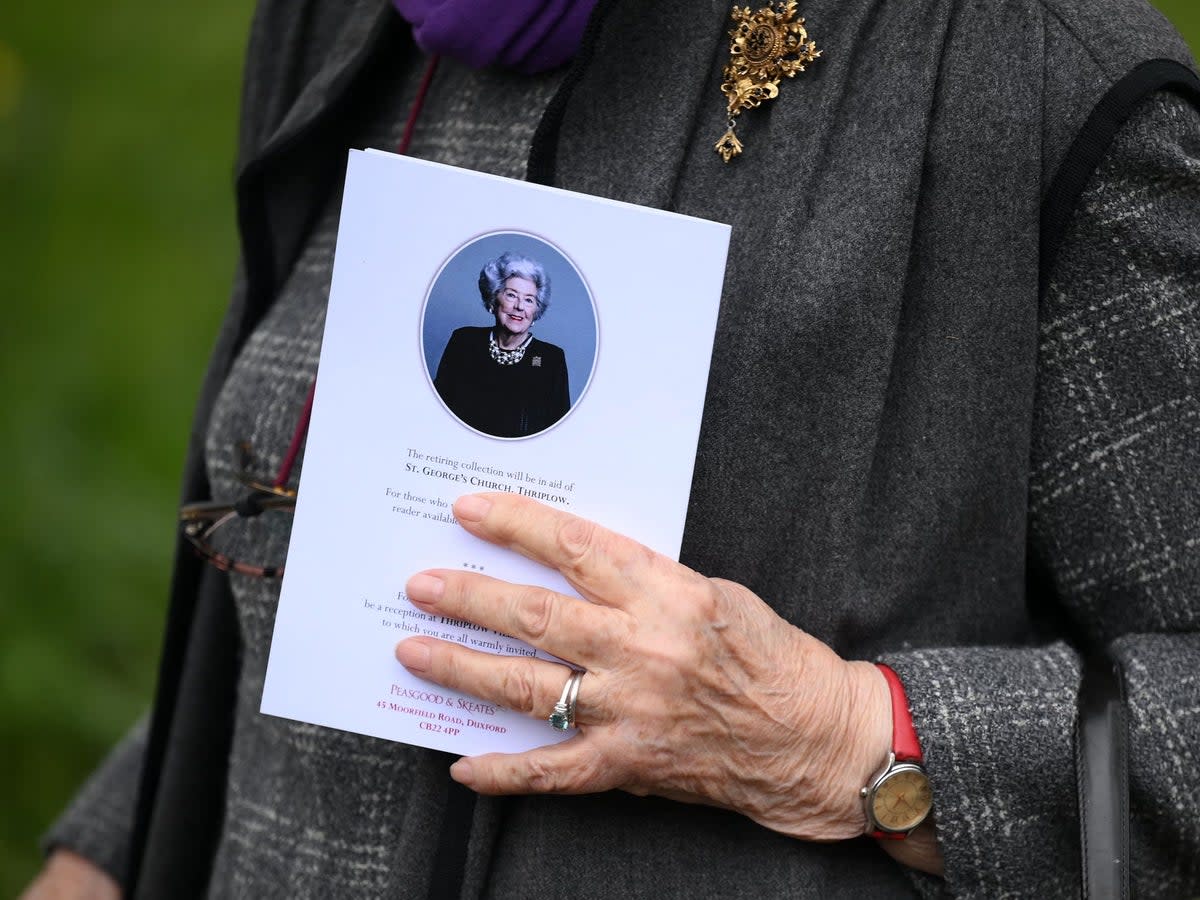 A mourner carries an order of service (AFP via Getty Images)