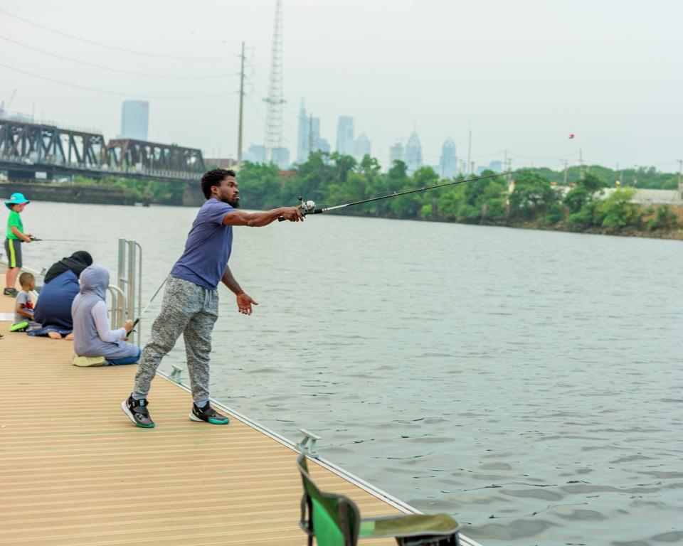 Neighbors enjoying weekly free fishing sessions on the expanded Bartram’s Garden dock on the tidal Schuylkill River in southwest Philadelphia, where more than 40 species of fish abound.