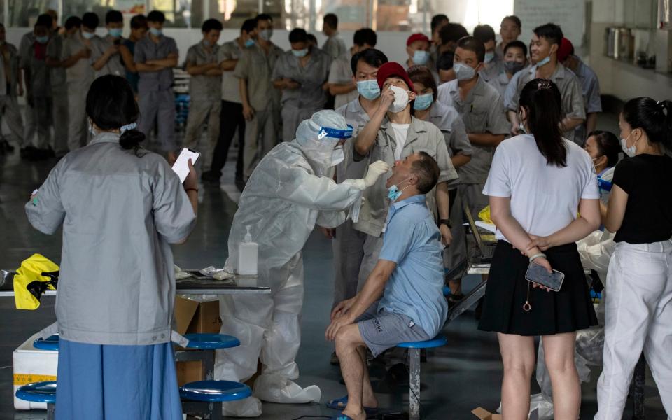 Workers at an auto parts manufacturer get tested for Covid-19 in the factory's canteen in Wuhan in central - Barcroft Media 