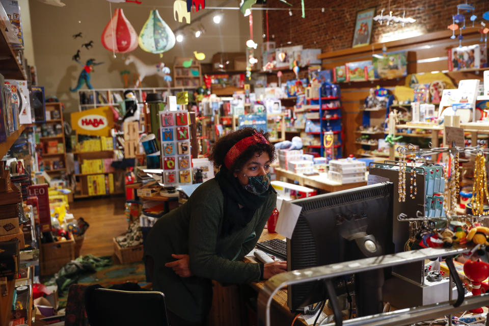 Sarah De Kinkajou, owner of Kinkajou toy shop, checks orders before opening her business in Brussels, Tuesday, Dec. 1, 2020. Non-essential shops in Belgium are reopening on Tuesday in the wake of encouraging figures about declining infection rates and hospital admissions because of the coronavirus. (AP Photo/Francisco Seco)