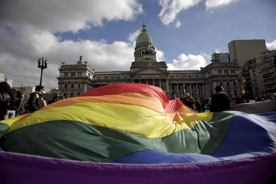 FILE - In this July 14, 2010 file photo, demonstrators wave a gay pride flag outside Congress in support of a proposal to legalize same-sex marriage in Buenos Aires. Argentina was the first country in Latin America to approve gay unions and in 2019 has some of the most progressive LGBT policies in the world. (AP Photo/Natacha Pisarenko, File)