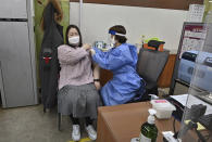 A nursing home worker, left, receives the first dose of the AstraZeneca COVID-19 vaccine at a health care center in Seoul Friday, Feb. 26, 2021. South Korea on Friday administered its first available shots of coronavirus vaccines to people at long-term care facilities, launching a mass immunization campaign that health authorities hope will restore some level of normalcy by the end of the year. (Jung Yeon-je /Pool Photo via AP)